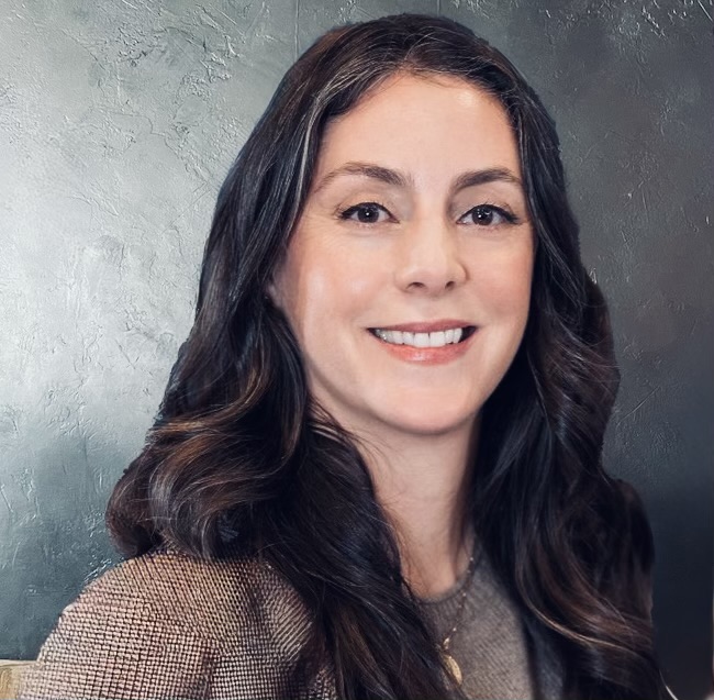 woman with long hair wearing a tan sweater