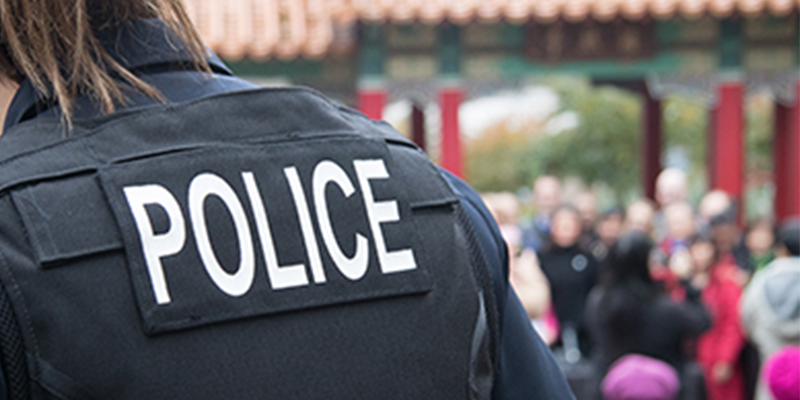 Back of a uniformed person with "POLICE" on their back