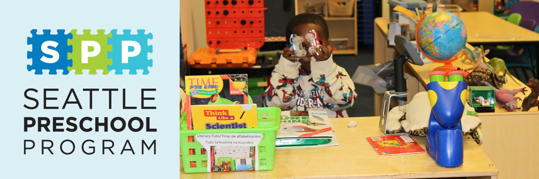 Child holding toy cars and books. 
