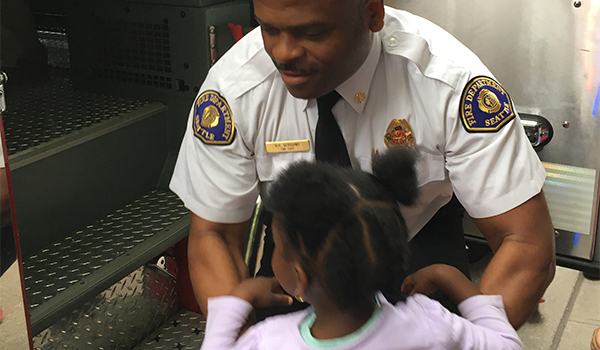 Fire Chief Harold Scoggins giving a child a tour of an apparatus.