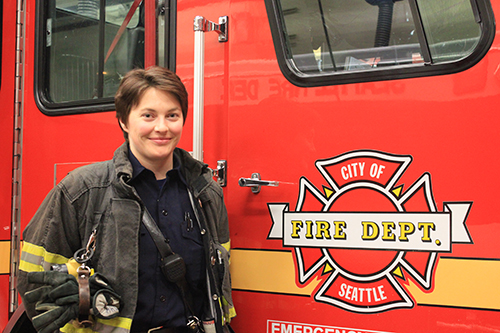 Firefighter standing next to their apparatus