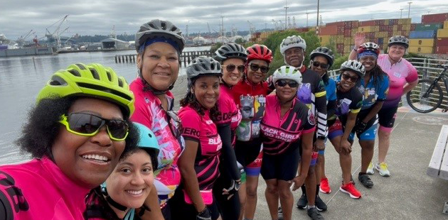Group cyclists on a ferry dock smiling