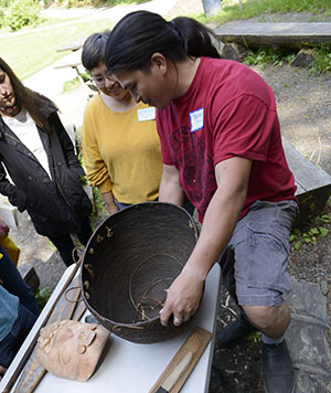 A volunteer holding and displaying a clay pot