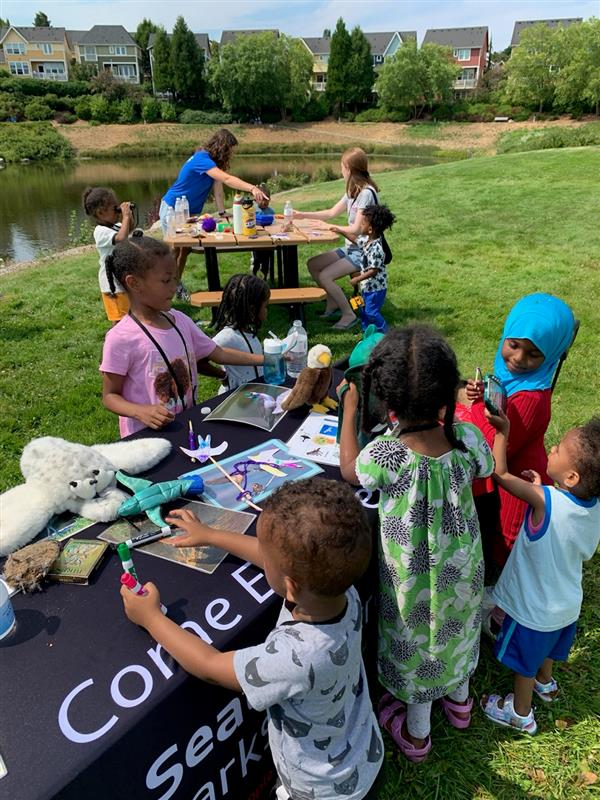 Young participants interact with artifacts at a table