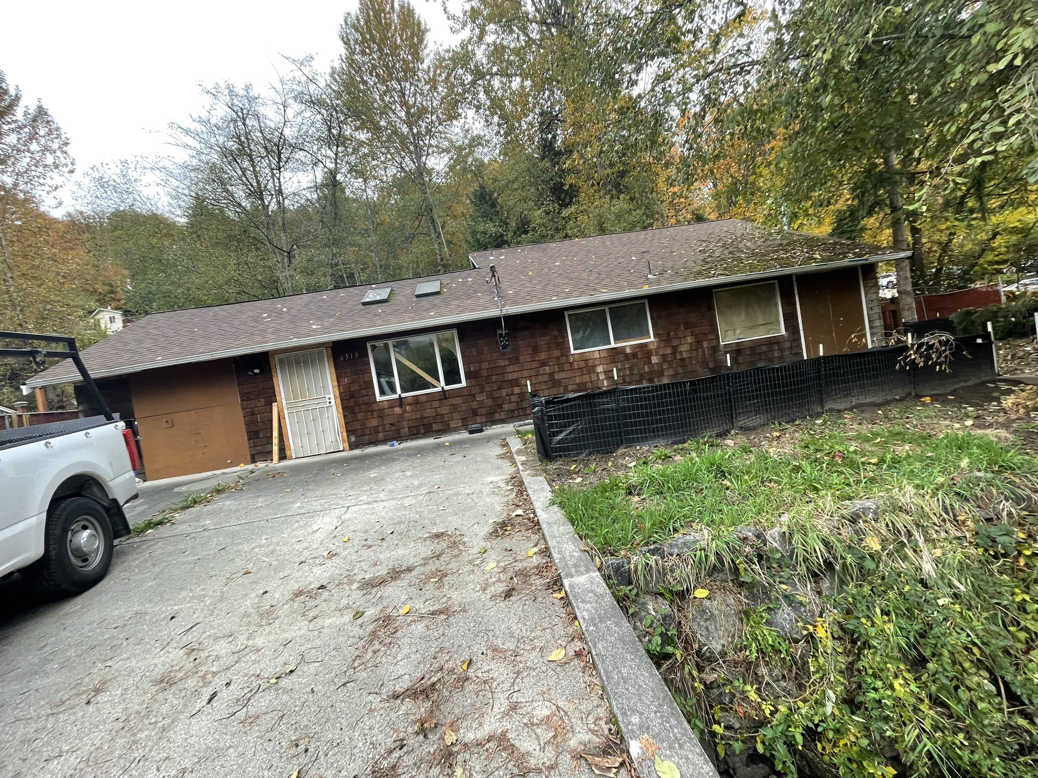 A boarded-up single story home, the start of a demolition project