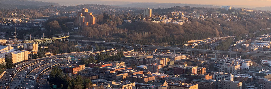 The Seattle skyline with many buildings of differing heights looking south over the freeway.