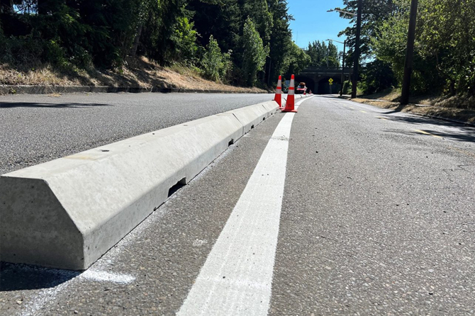 A close up of a low precast concrete parking stops on a street