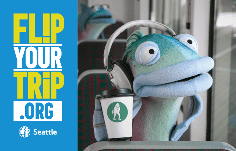 Sal the Salmon looking out a bus window with the logo "Flip Your Trip"