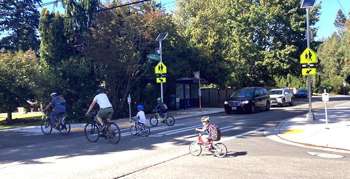 Adults and children on bicycles using the Greenway