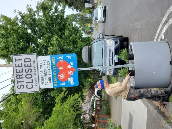 Person planting plants into a planter in the street