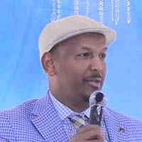 Abdirahman speaking into a microphone against a violet background