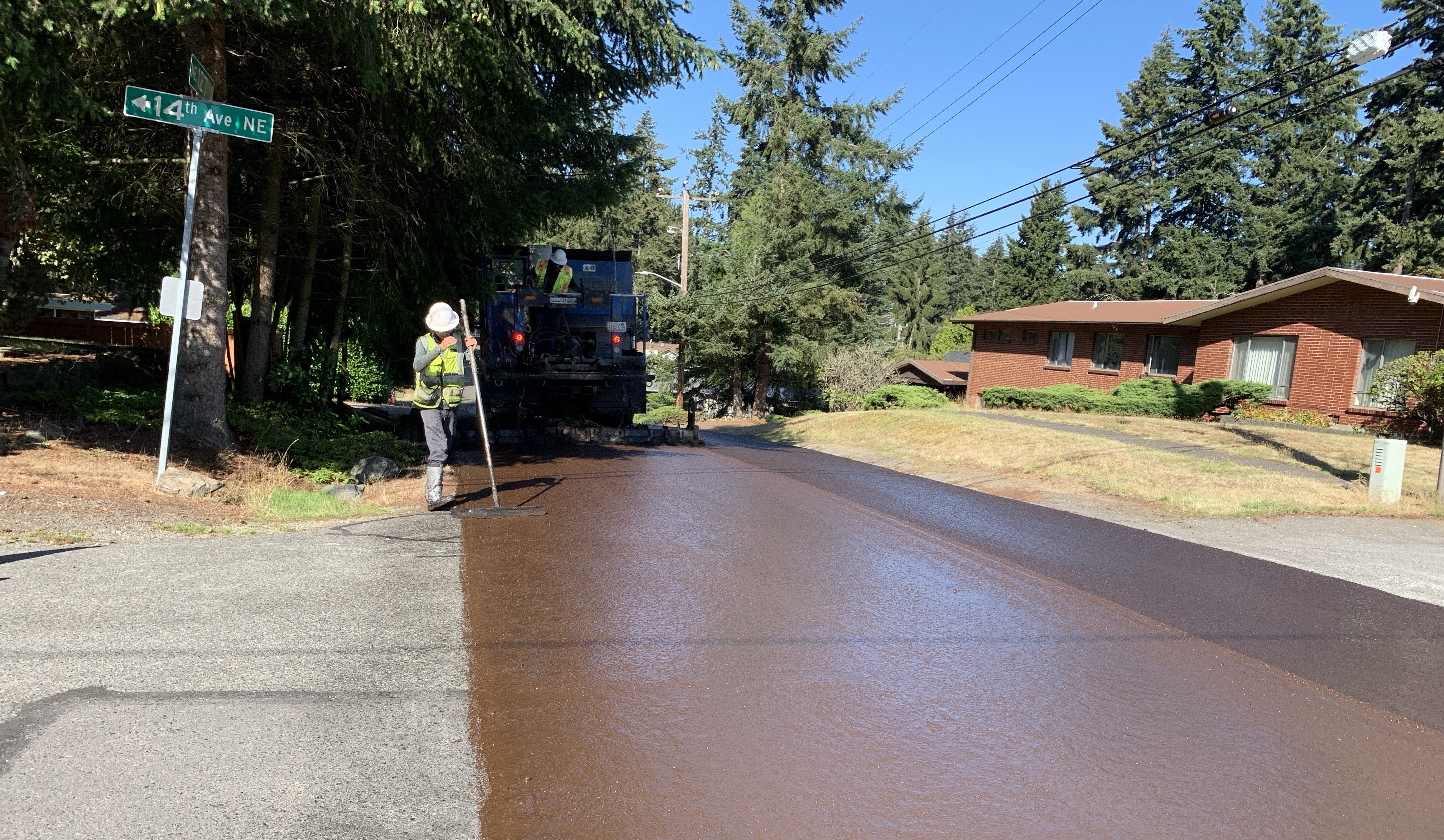 Image shows a street being coated with slurry seal