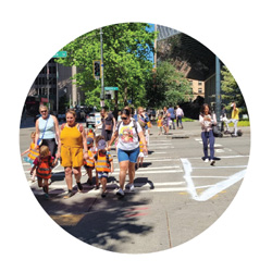 पैदल यात्री एक चौड़े क्रॉस वॉक को पार करते हुए