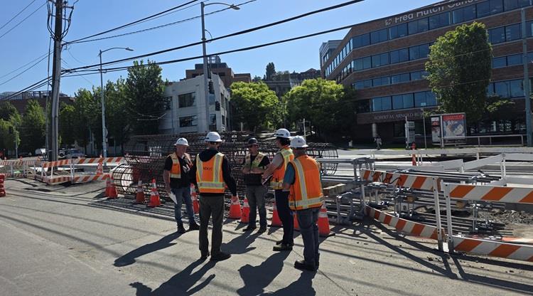 The image shows the construction team members meeting on Fairview Ave N to plan the work needed to be ready for the FIFA World Cup