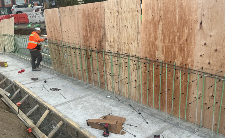 images shows wood panels being stood in place so that we can pour concrete foundations for the retaining wall on Eastlake