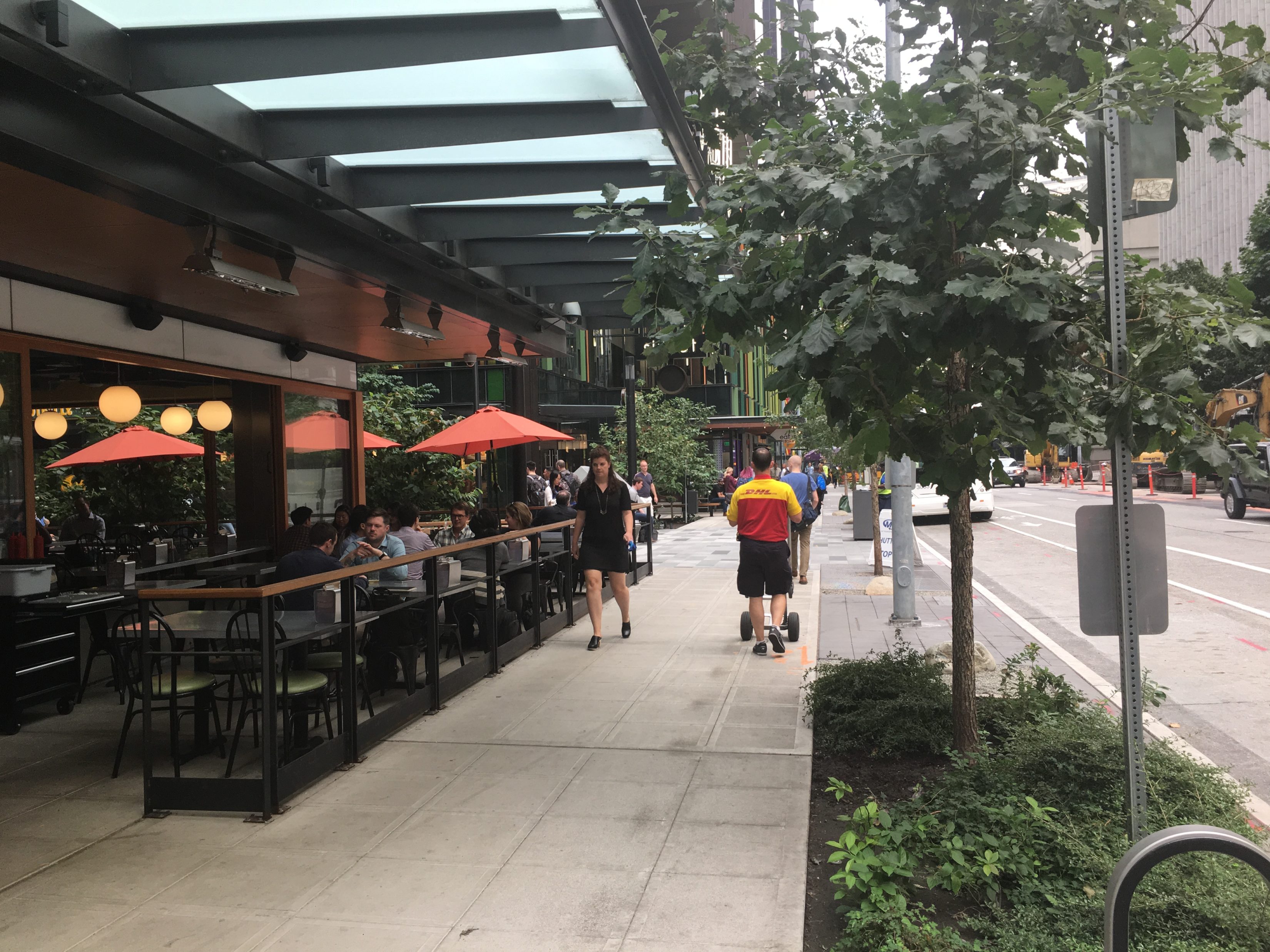 Pedestrian clear zone. Six feet of pedestrian clear space between a sidewalk cafe with a fence and a landscape strip with trees.
