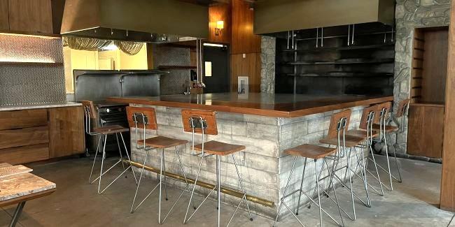 배경에 테이블과 주방이 보이는 바가 있는 빈 식당 