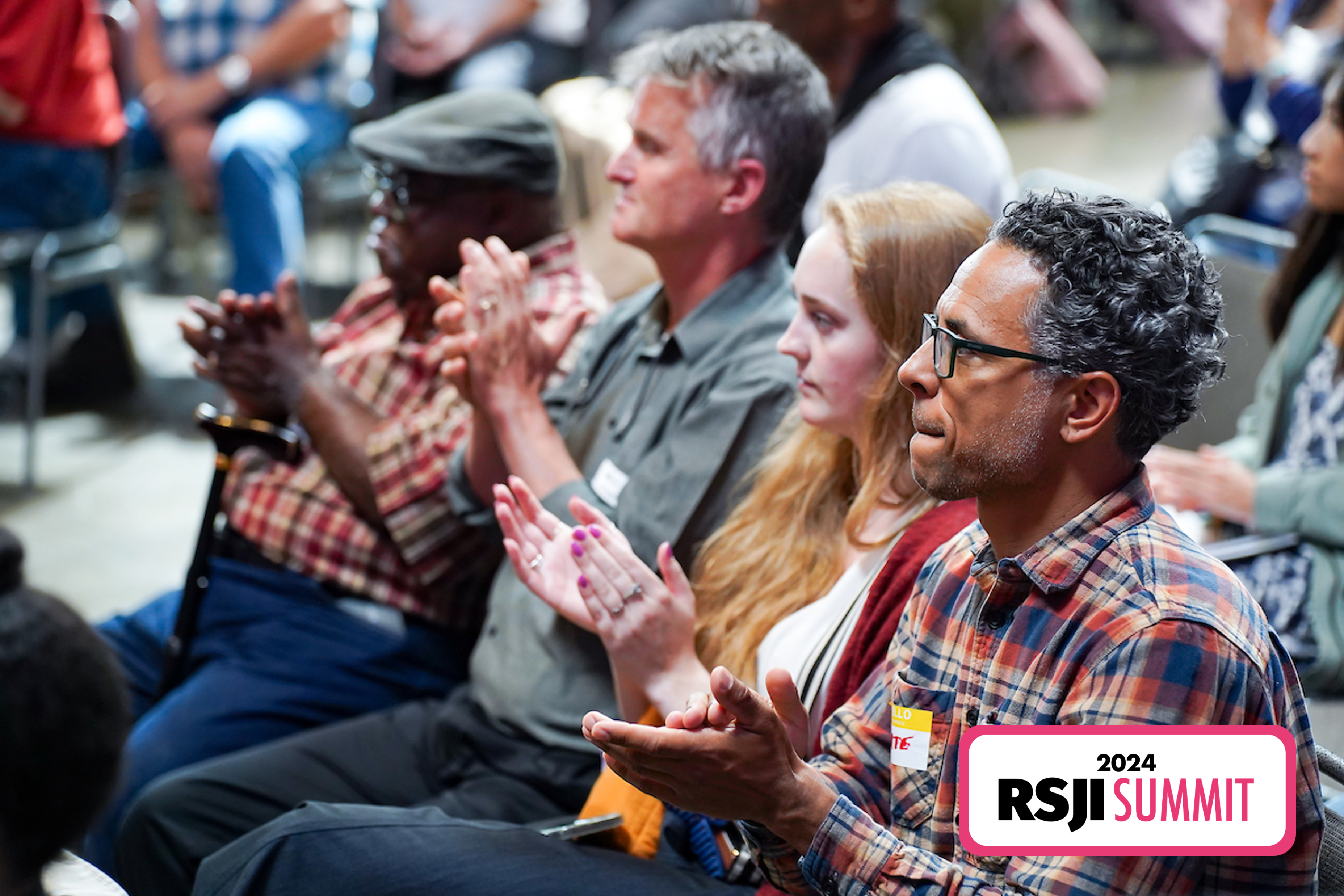 Audience members clapping at the 2024 RSJI Summit