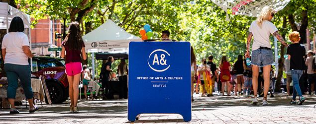 The Seattle Office of Arts & Culture a-frame in the middle of a Pioneer Square event.