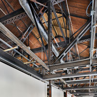 The bones of the building can be seen: wooden roof lines, crisscrossing steel beams.