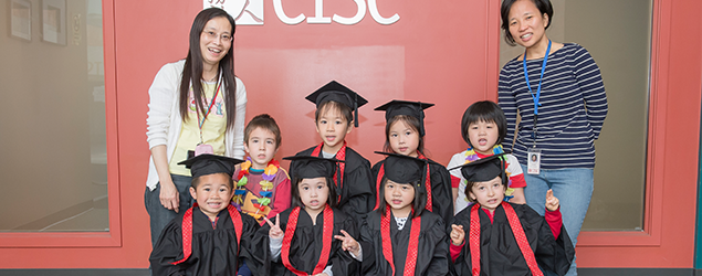 A graduating class of preschoolers in black robes.