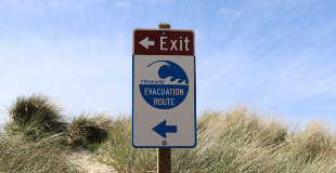 A sign on road that states Evacuation Route.