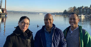 Community engagement coordinators standing together smiling with the Salish Sea in the background.