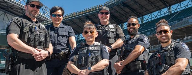 Seattle Police officers pose in a group at a sporting venue