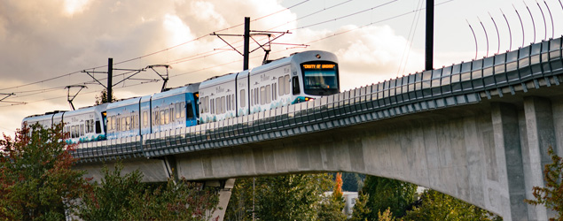 Link light rail on an elevated track with dramatic clouds behind