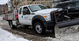 An SDOT snow plow moving snow off the street