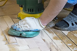 Person sanding reusable floor.