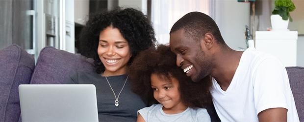 People smiling and using a laptop.