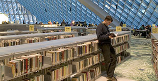Young man reading a book at the central library