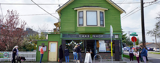 People stand in front of a cake shop